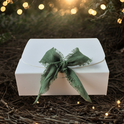 White box with a green bow on a dark background with lights